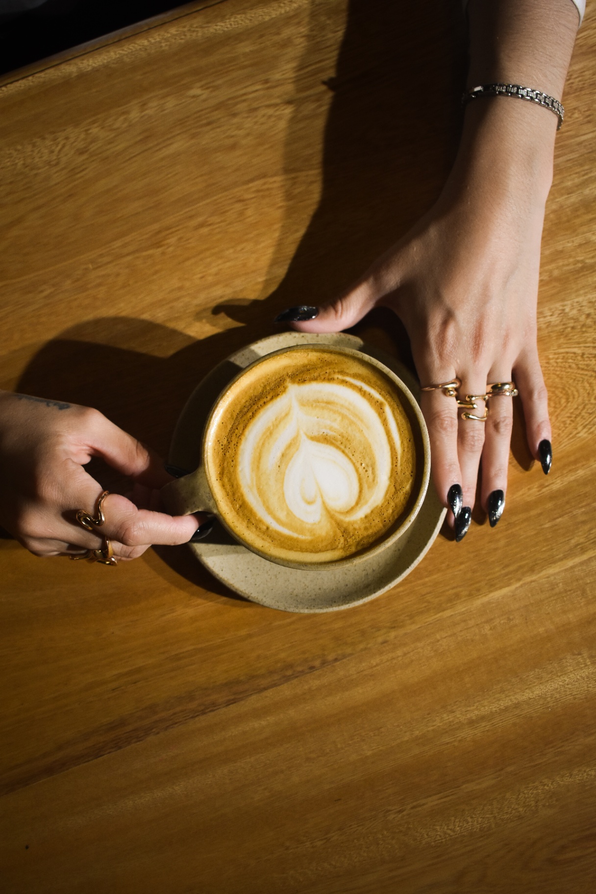 Latte art servido en cerámica sobre mesa de madera