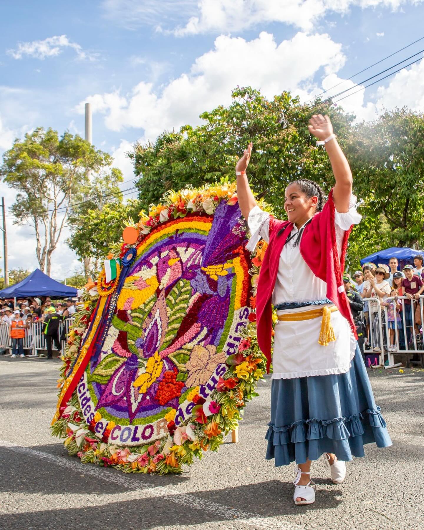 Silletera desfilando con una silleta monumental llena de flores en Medellín